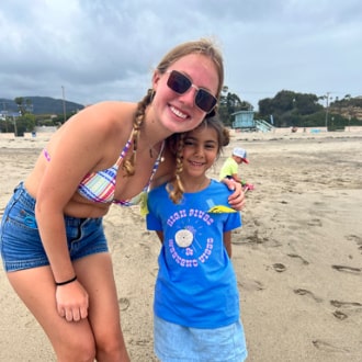 Female camp counselor with a camper on the beach.