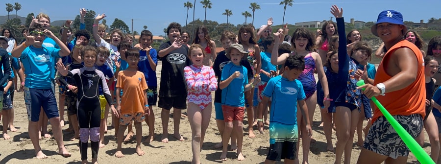 Aloha Beach Camp counselor Hunter hanging out with Kahuna and Nalu campers getting ready for a ocean swim session at Zumba Beach, Malibu