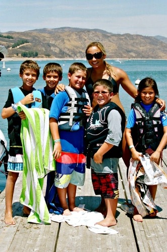 Camp counselor Jacquelyn Derian with group of boys and girls wearing lifejackets standing on the boat dock at Castaic Lake.
