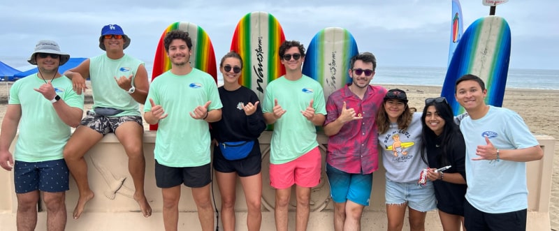 9 counselors and directors in front of surf boards at Aloha Beach Camp at Zuma Beach Malibu